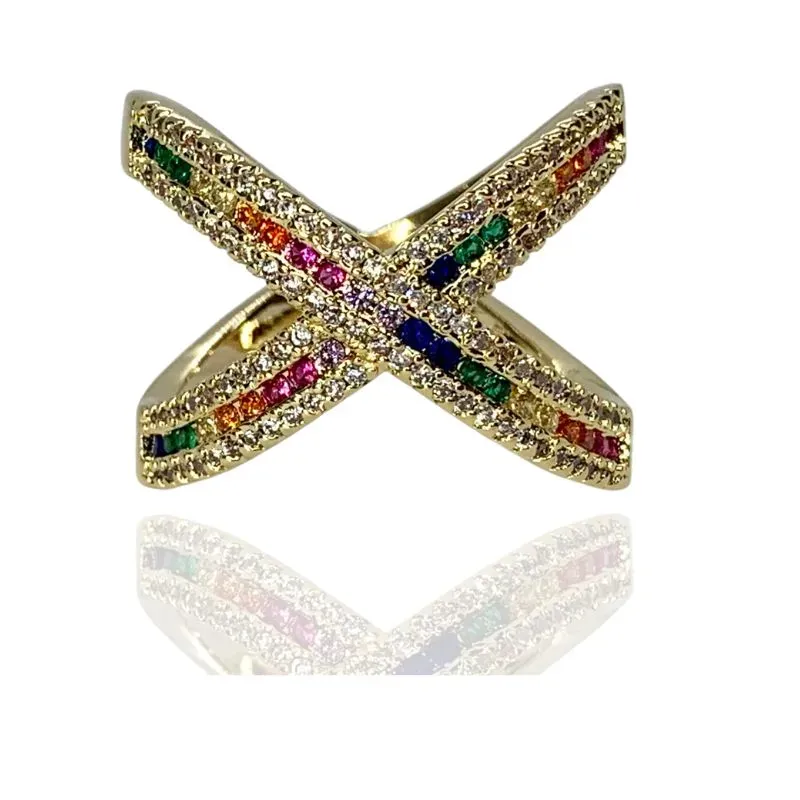 ANEL EM FORMATO X COM CRAVAÇÃO COLORIDA NO MEIO E CRISTAL DOS LADOS ANEL EM FORMATO X COM CRAVAÇÃO COLORIDA NO MEIO E CRISTAL DOS LADOS